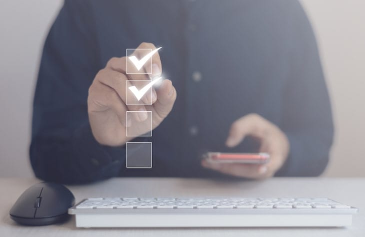Person checking off a virtual checklist, symbolizing progress in SOC 2 compliance.